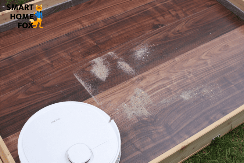 Ecovacs Deebot T9 reinigt Sand beim Saugtest auf dem Hartboden